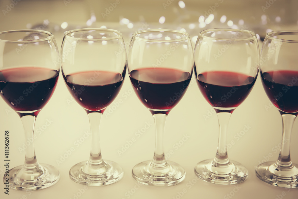 Glasses of red wine on white table closeup