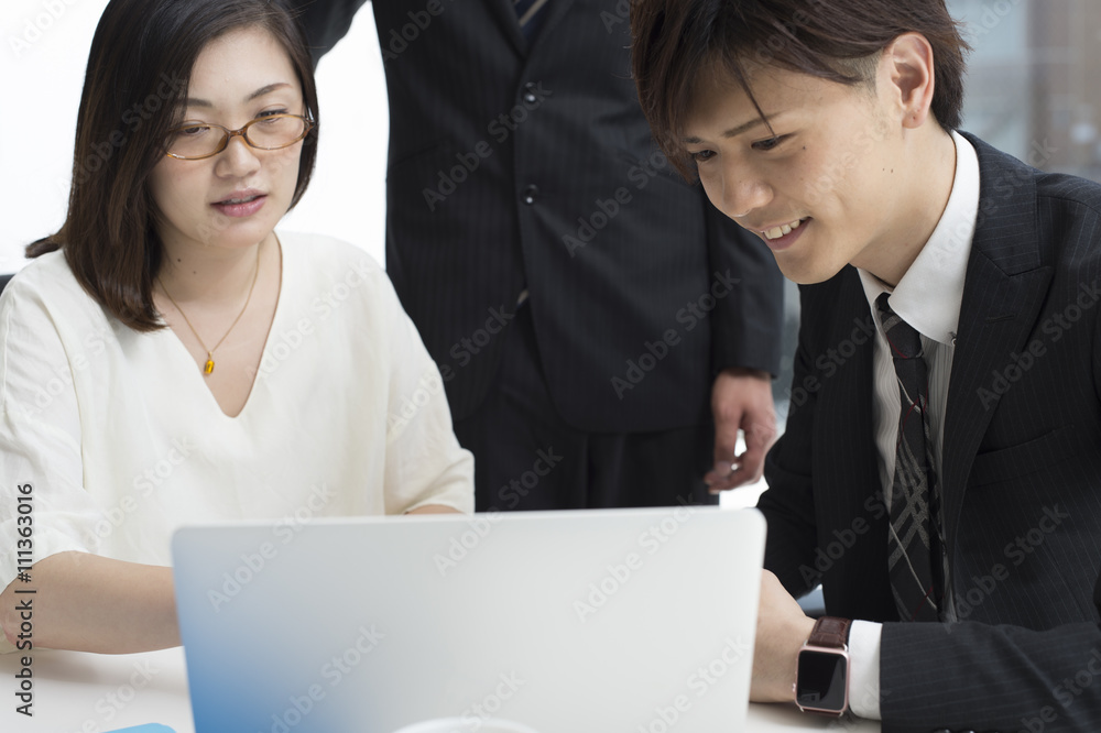 Three businessmen looking at a laptop in the company Three businessmen looking at a laptop in the company