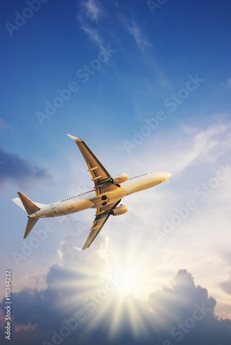 Airplane with sun ray on blurred sky