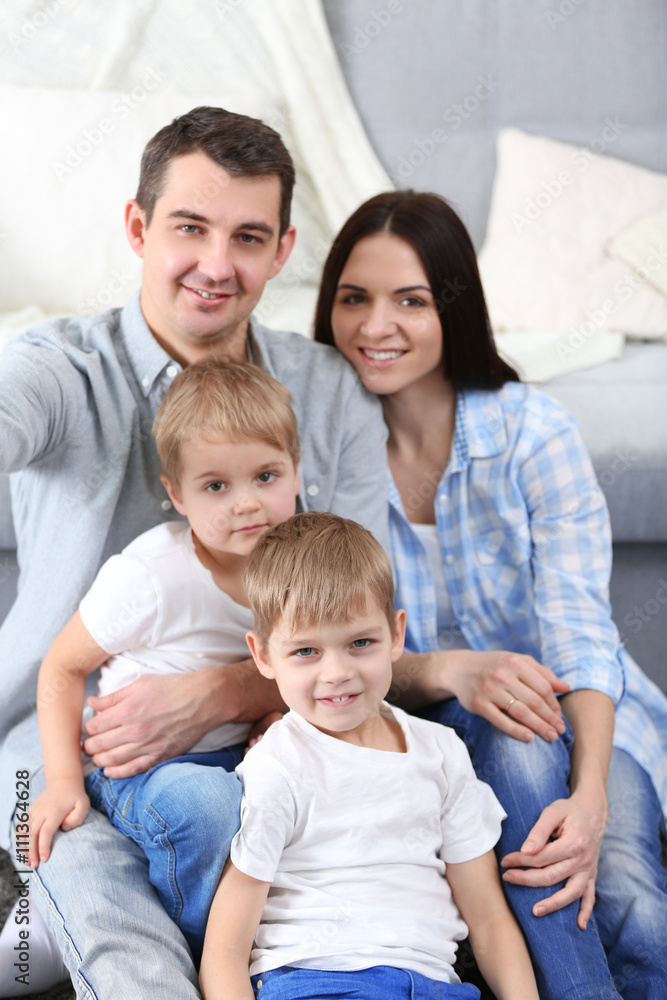 Happy family sitting on floor  on couch background, closeup