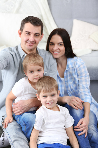 Happy family sitting on floor on couch background, closeup