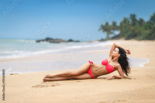 Beautiful girl in a sexy pink bikini on the beach