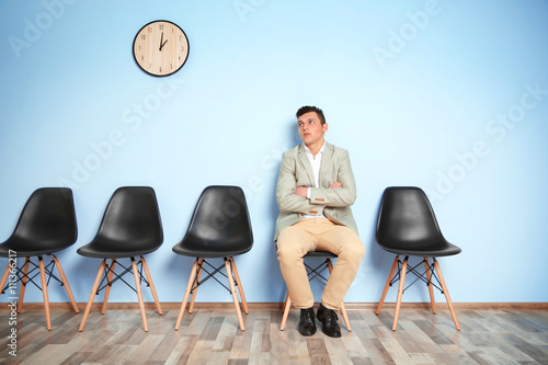 Young man in suit sitting o...