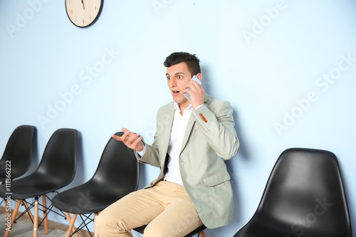 Young man in suit talking o...