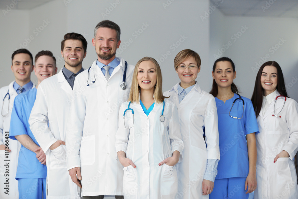 A group of doctors and nurses standing in the hospital, indoors A group of doctors and nurses standing in the hospital, indoors
