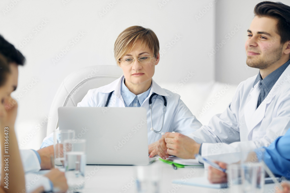 Medical doctors sitting at the meeting in modern hospital Medical doctors sitting at the meeting in modern hospital