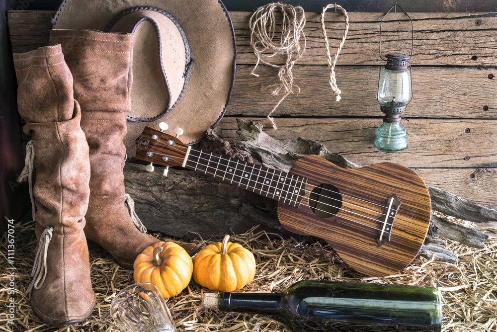 ukulele with american west rodeo brown cowboy hat and leather boots in  vintage ranch barn studio background, Still life style Stock Photo | Adobe  Stock