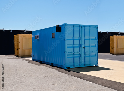 Blue and yellow mobile shipping containers in industriall site