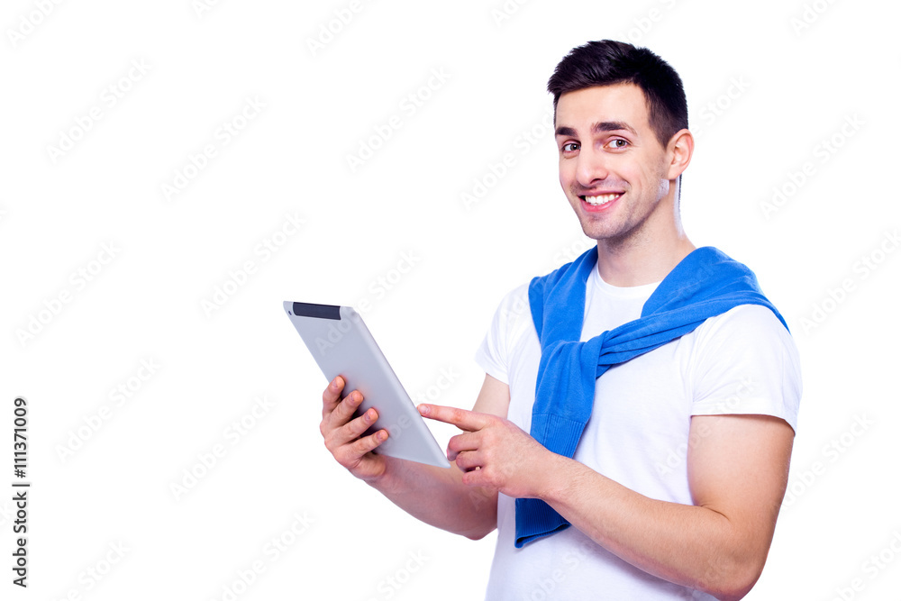 Smart technology makes everything easier. Confident young man in shirt working on digital tablet and smiling while standing against white isolated background