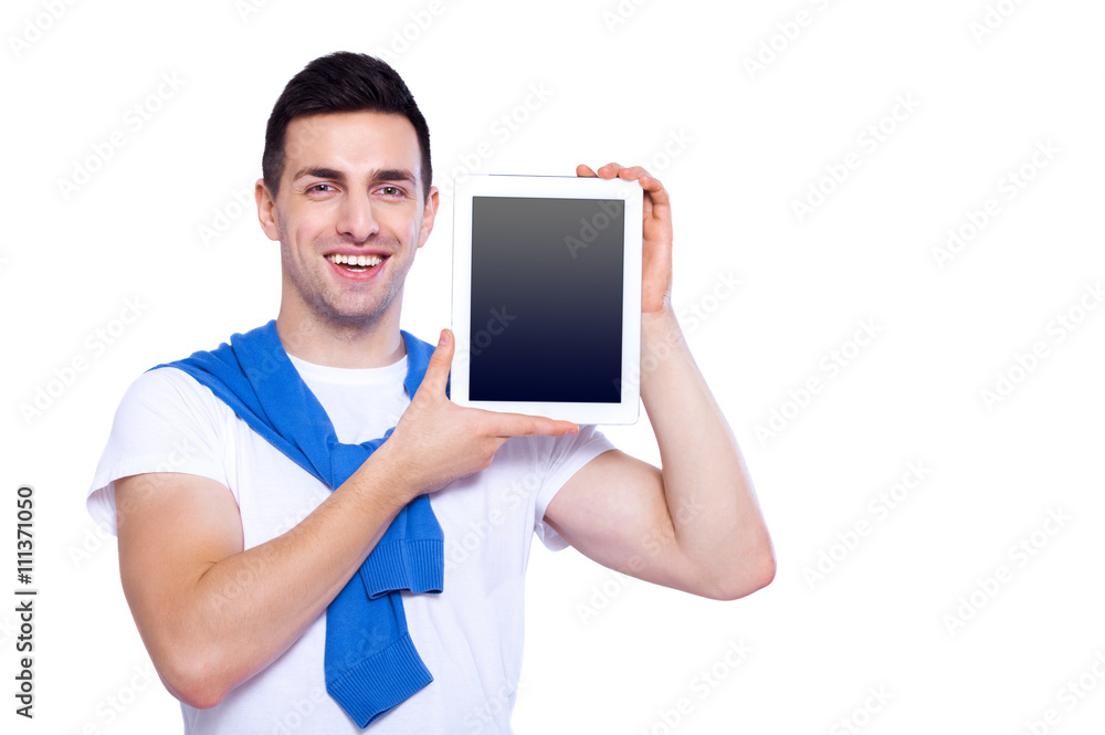 Copy space on his tablet. Happy young man showing his digital tablet and smile while standing isolated on white background