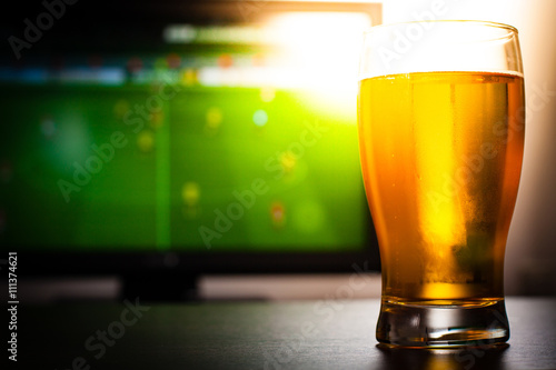 Foto Pint of beer on the tabele in front of televisor show off football