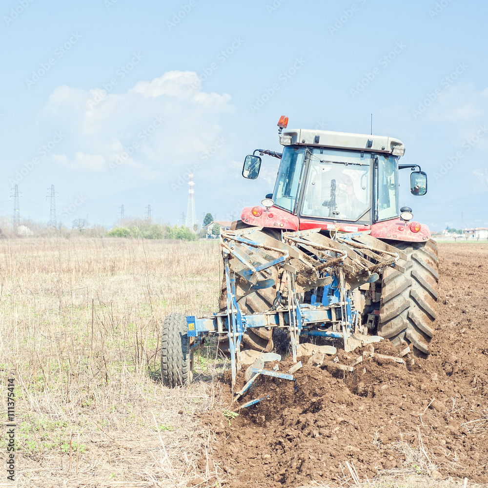 Fototapeta premium Tractor plowing the stubble field