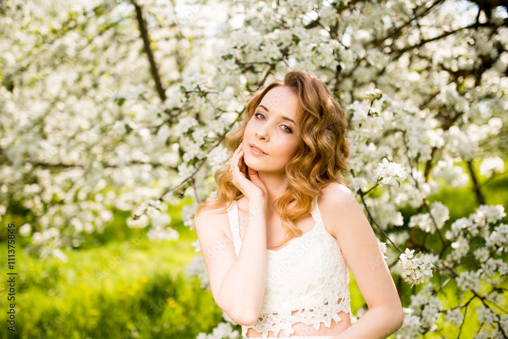 Spring beautiful girl, blonde, standing in a blooming Apple orchard . Spring beautiful girl, blonde, standing in a blooming Apple orchard .