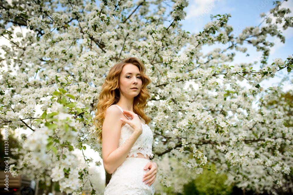 Spring beautiful girl, blonde, standing in a blooming Apple orchard . Spring beautiful girl, blonde, standing in a blooming Apple orchard .