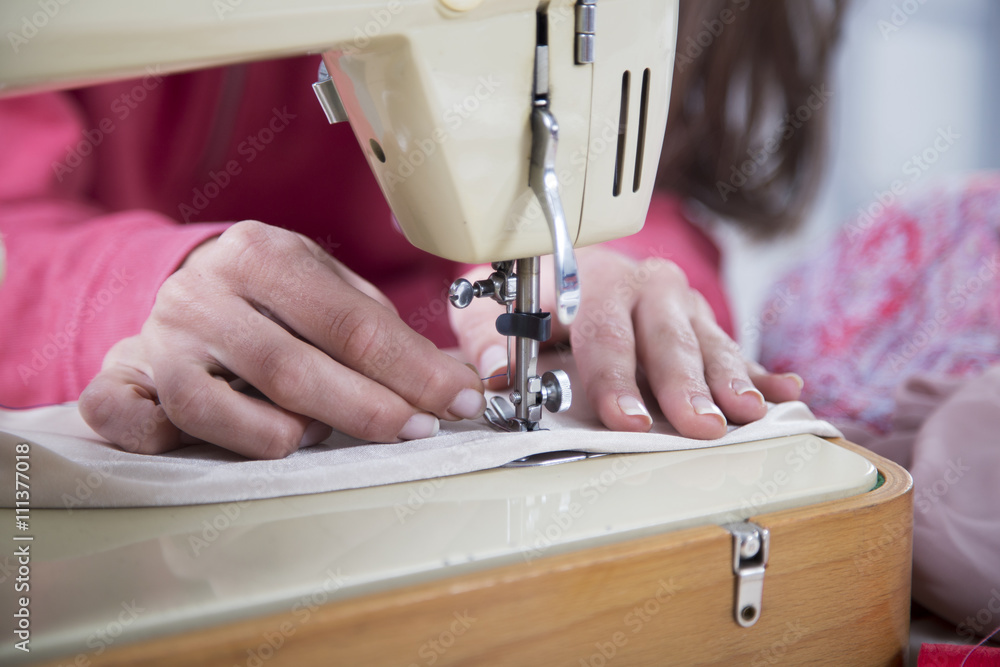 Sewing Process - Women's hands behind her sewing,selective focus

