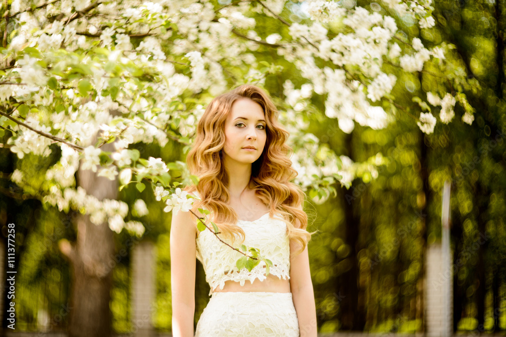 Spring beautiful girl, blonde, standing in a blooming Apple orchard . Spring beautiful girl, blonde, standing in a blooming Apple orchard .