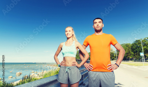 happy couple exercising at summer seaside © Syda Productions