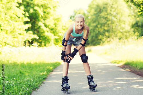 happy young woman in rollerskates riding outdoors