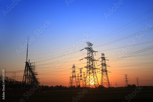 The silhouette of the evening electricity transmission pylon