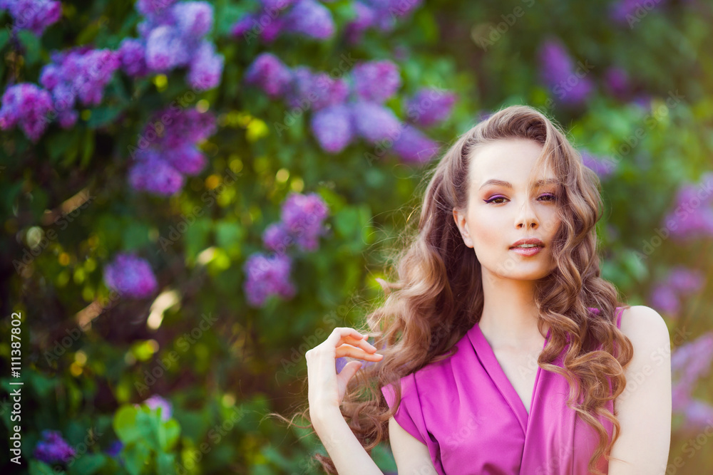 Young beautiful girl posing near lilac bushes in blossom Young beautiful girl posing near lilac bushes in blossom