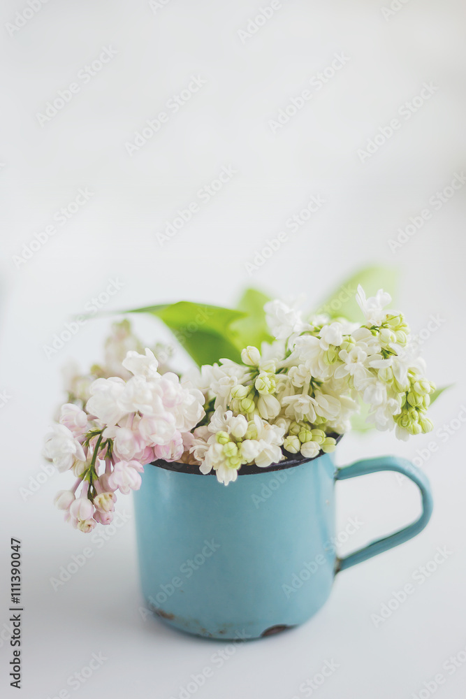Lilac flowers in old rusty mug. Natural spring background. Place for text.