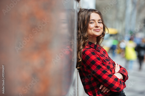 Woman with arms folded leaning on the wall