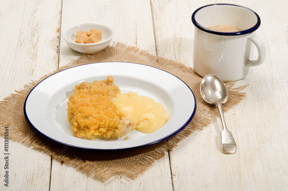 british apple crumble with custard on enamel plate british apple crumble with custard on enamel plate