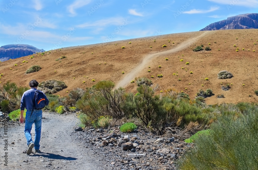 Man with his backpack walking to the top of  mountain. Concept for travel or  success