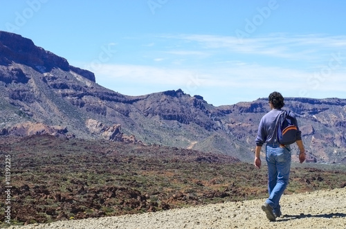 Man with his backpack walking on volcanic mountains of Tenerife. Concept for travel o tourism © vasanty
