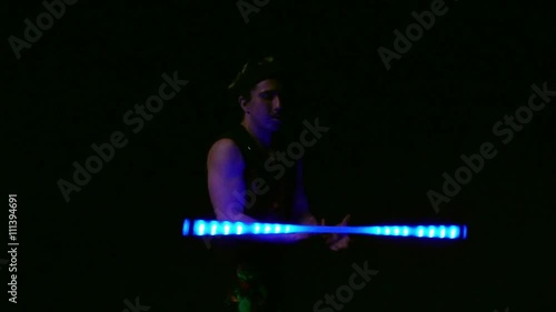 Juggler showing tricks with light balls in the whole dark.Close up.Slow motion photo