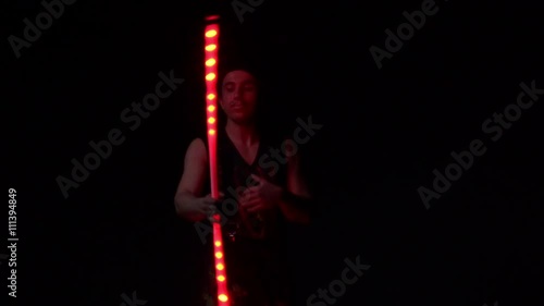 Juggler showing tricks with light balls in the whole dark.Close up.Slow motion photo