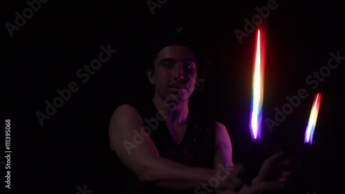 Juggler showing tricks with light balls in the whole dark.Close up.Slow motion photo