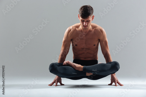 Handsome man doing yoga exercises