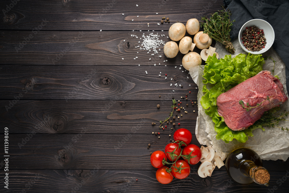 raw meat with ingredients on a wooden background raw meat with ingredients on a wooden background