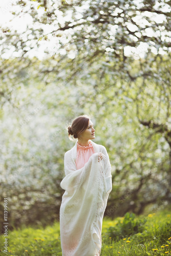 Happy woman stands in the middle of a blossoming garden Happy woman stands in the middle of a blossoming garden