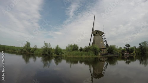 Kinderdijk Childrens Dike boat passing single windmill view from water from the canal  windmills Unesco World Heritage Unique Dutch sight and the most popular tourist attraction in The Netherlands 4k photo