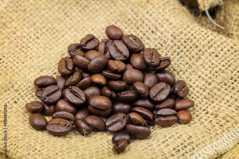 Fototapeta premium Roasted coffee beans on sackcloth background