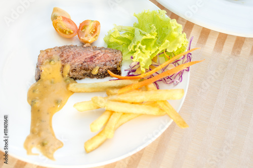 beef steak and vegetables with tomatoes and french fries