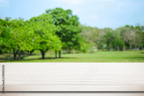 Empty white table over blurred park with bokeh background