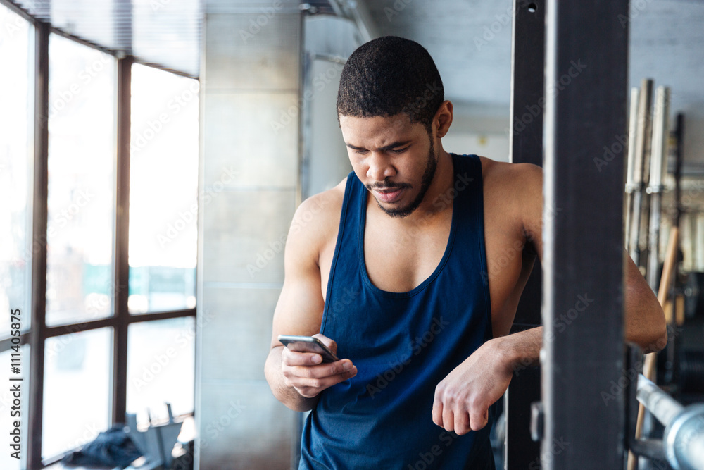 Fitness man using smart phone in the gym Fitness man using smart phone in the gym