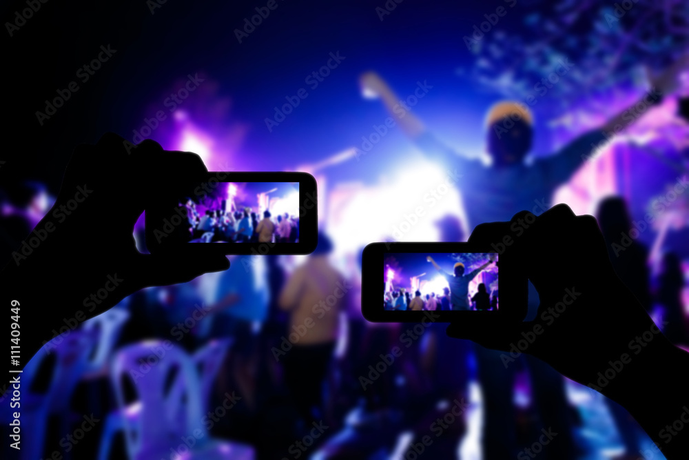 Take photo crowd in front of concert stage blurred