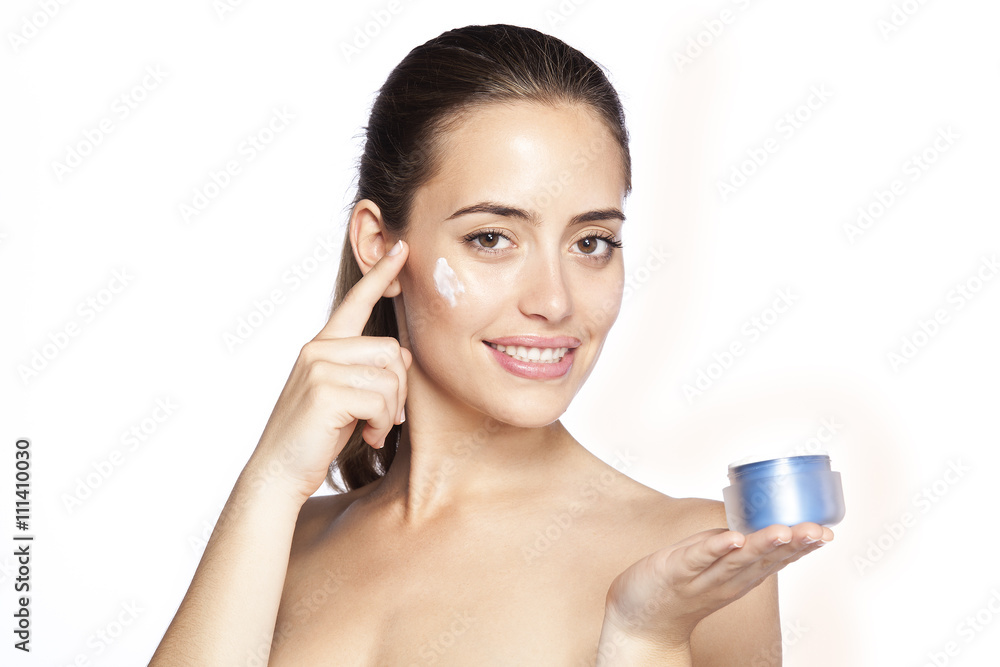 Beautiful girl is applying cream on her check. Skin care concept. Isolated on white background Beautiful girl is applying cream on her check. Skin care concept. Isolated on white background