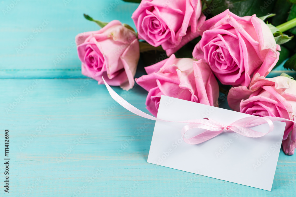Pink Rose flower with empty note for your message. Wooden backgr
