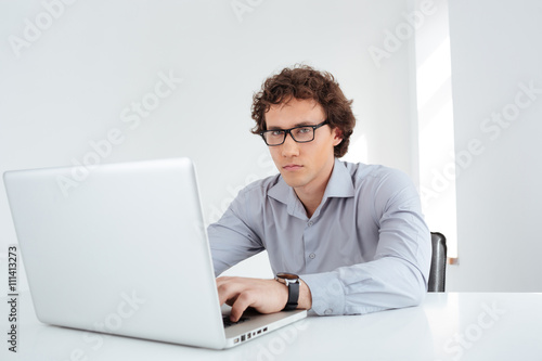 Businessman in glasses working on laptop computer