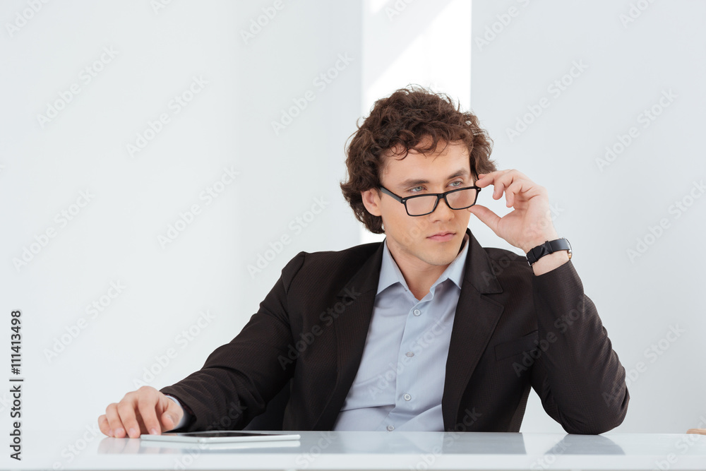 Serious businessman sitting at his workplace Serious businessman sitting at his workplace