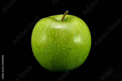 Зеленое яблоко на черном фоне крупным планом photo