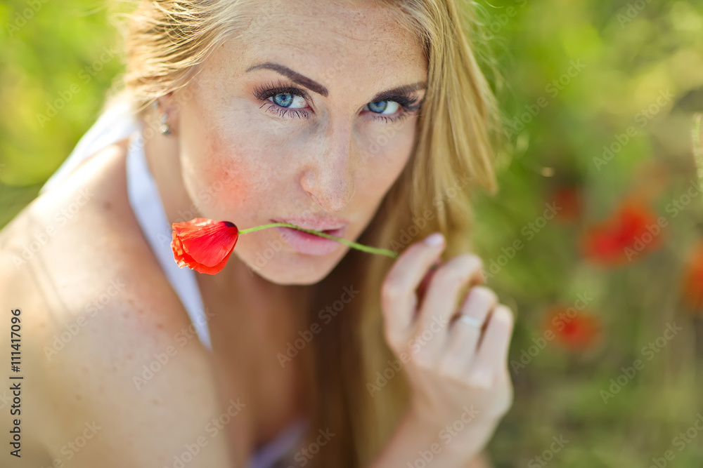 Portrait of beautiful woman in a flowers field