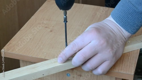 drilling holes in the wooden rail

