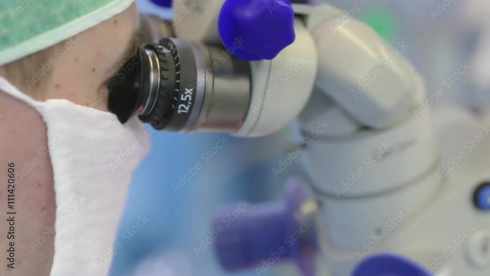 Surgeon look in microscope during operation Surgeon look in microscope during operation