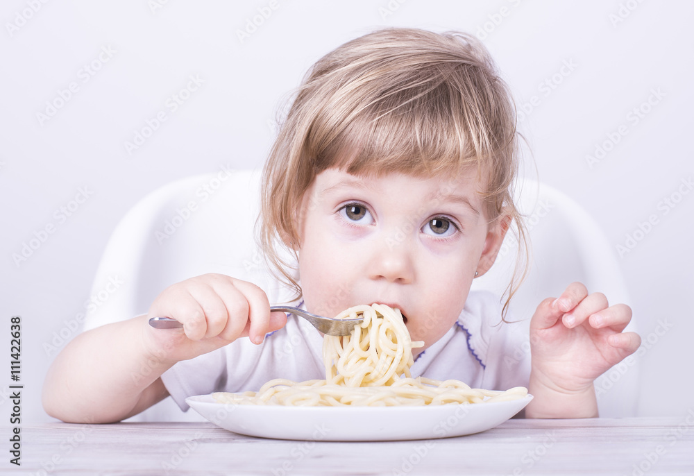 Child eating and playing with spaghetti and fork. Child eating and playing with spaghetti and fork.
